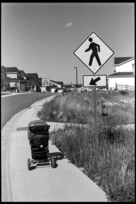 neighborhood road sign pointing to stroller